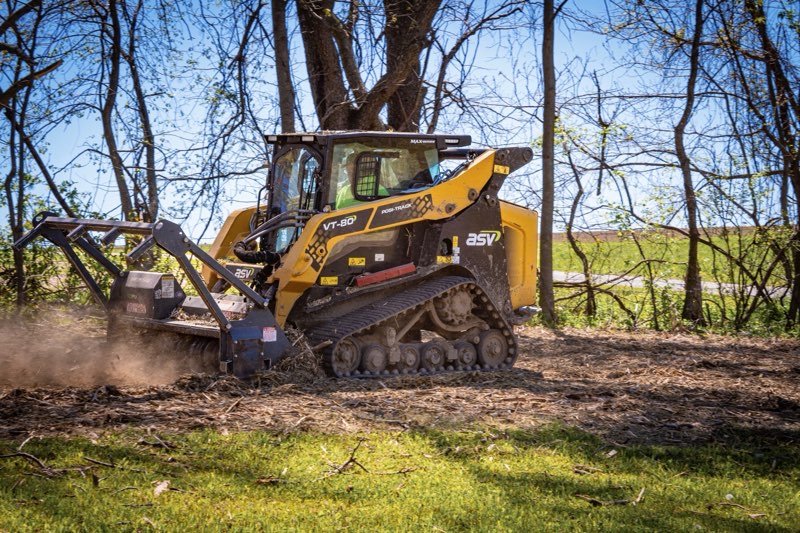 Forestry mulcher clearing brush in a wooded area